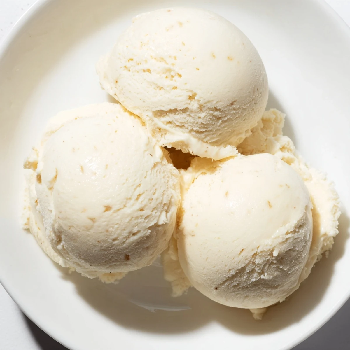Homemade Creamy Treat Ice Cream overflowing from a waffle cone on a summer picnic table.