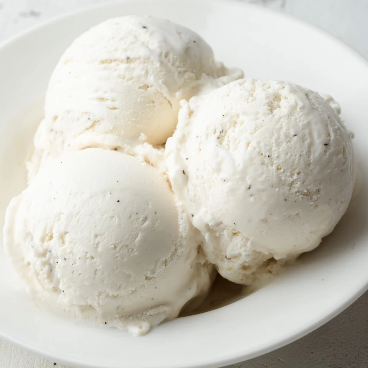 A rustic wooden scoop of Creamy Treat Ice Cream is served beside fresh strawberries and mint.