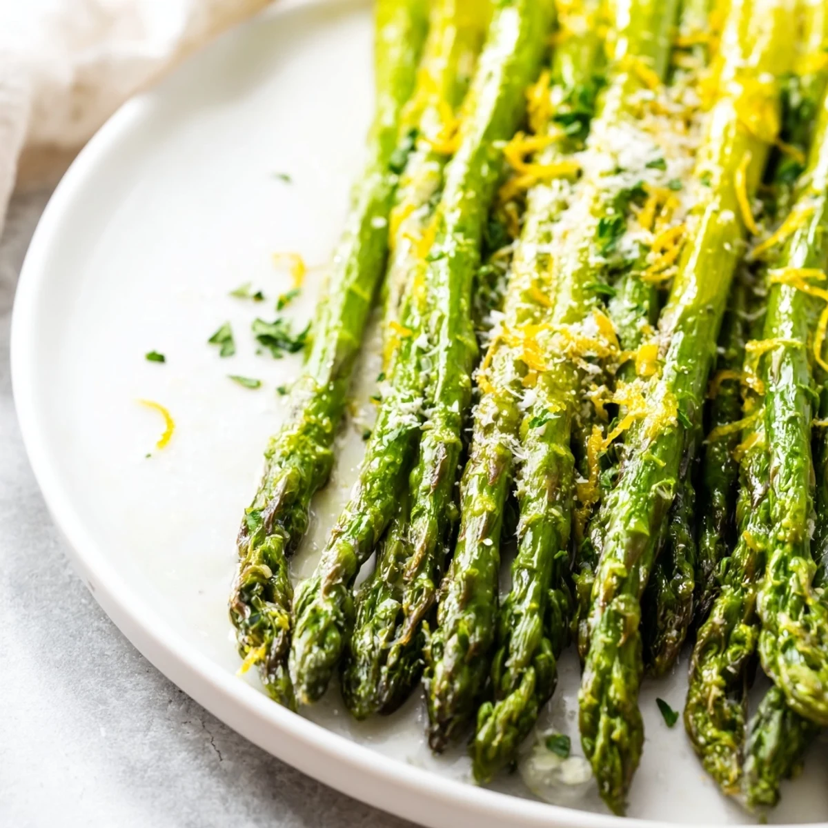 Tender roasted asparagus with Parmesan and lemon, glistening with olive oil and served warm as a bright, healthy side.