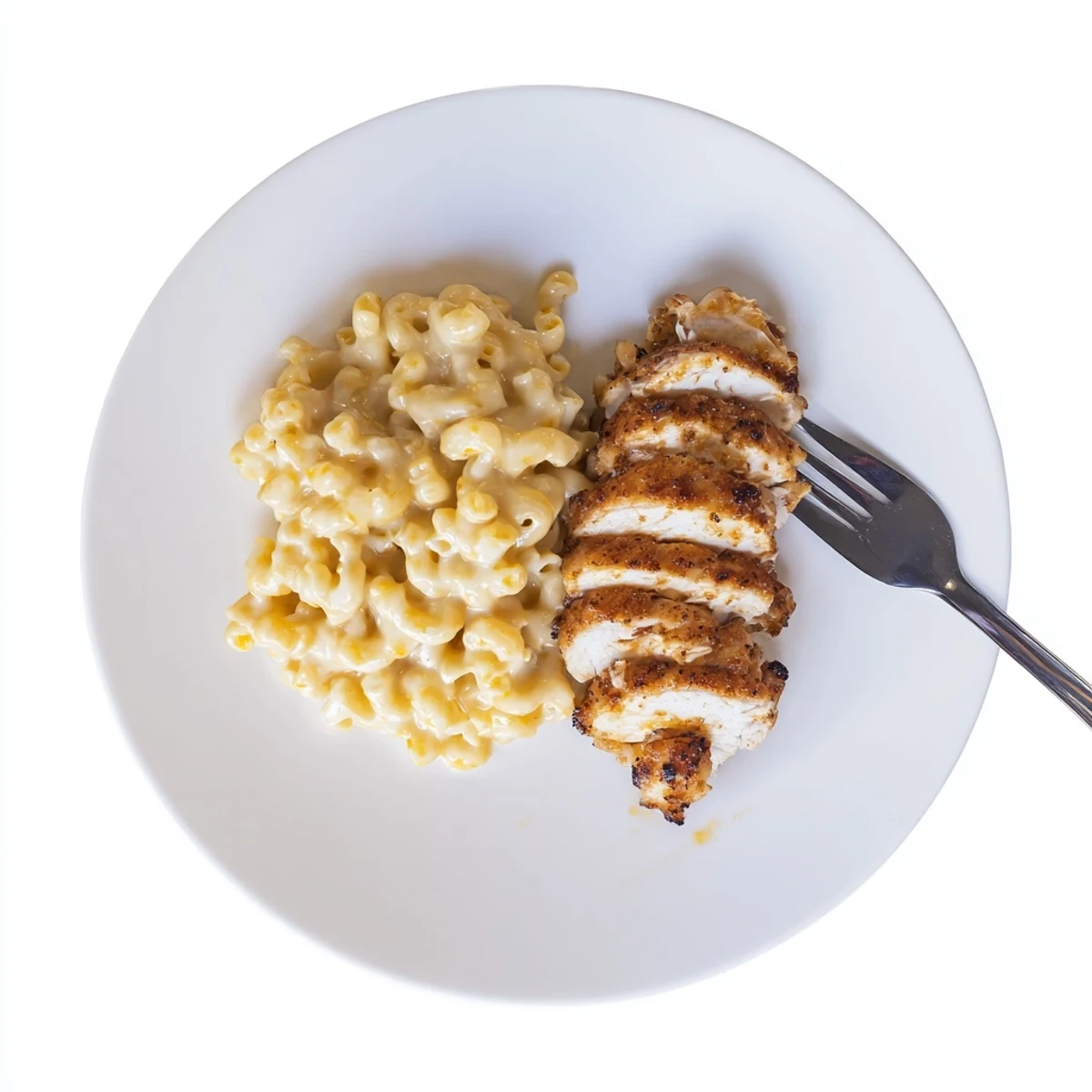 Glazed chicken breasts on a white plate alongside creamy mac and cheese, showcasing the Sweet and Spicy Honey Pepper Chicken with Creamy Mac and Cheese.