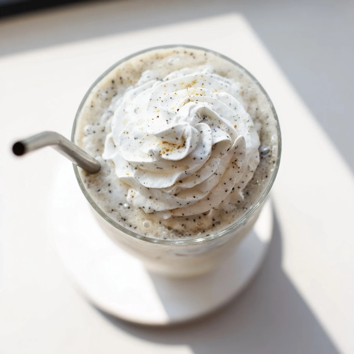 A blender-filled Vanilla Bean Frappuccino poured into a glass, evoking a refreshing coffeehouse-style treat.