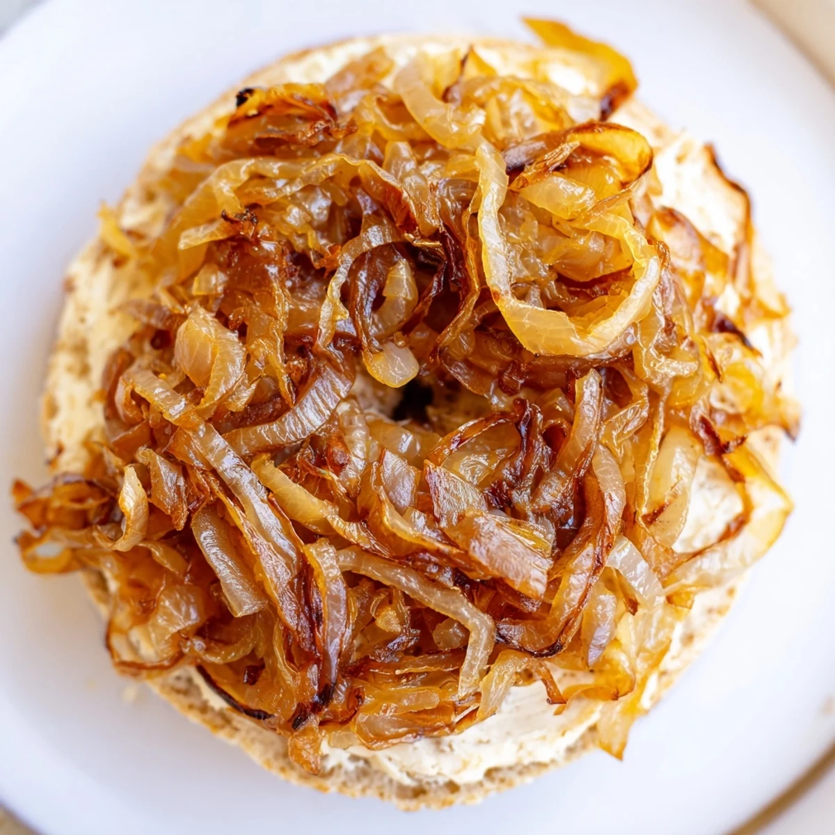Freshly baked Sourdough Onion Bagels with golden caramelized onions on a wooden board, ready for brunch.