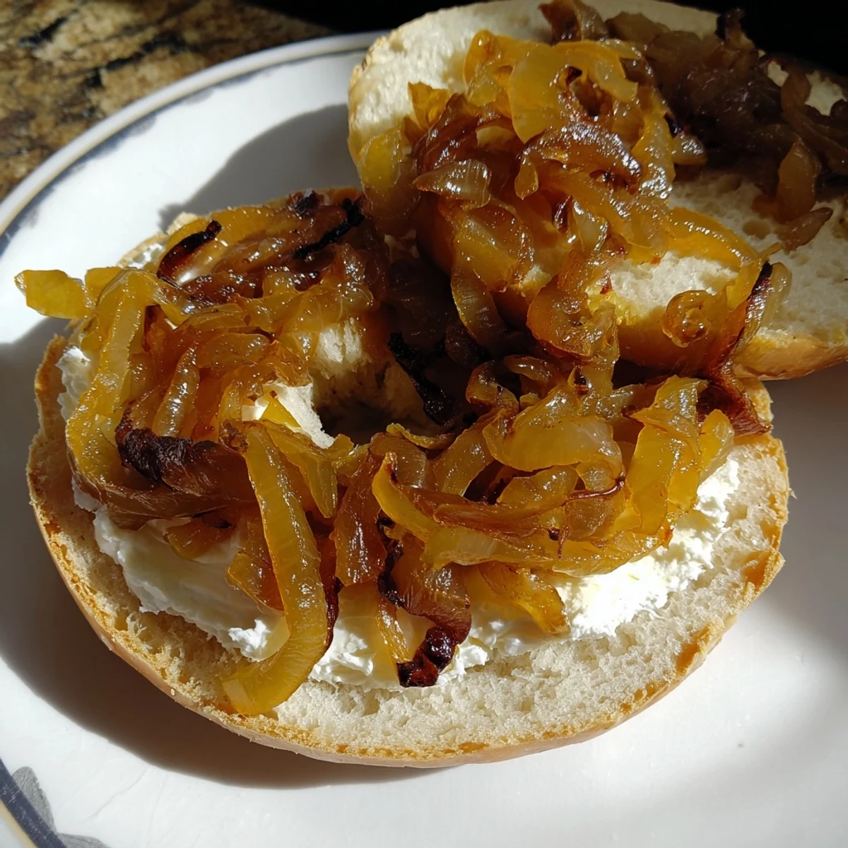 Homemade Sourdough Onion Bagels with chewy texture and sweet onion topping, served warm with cream cheese.