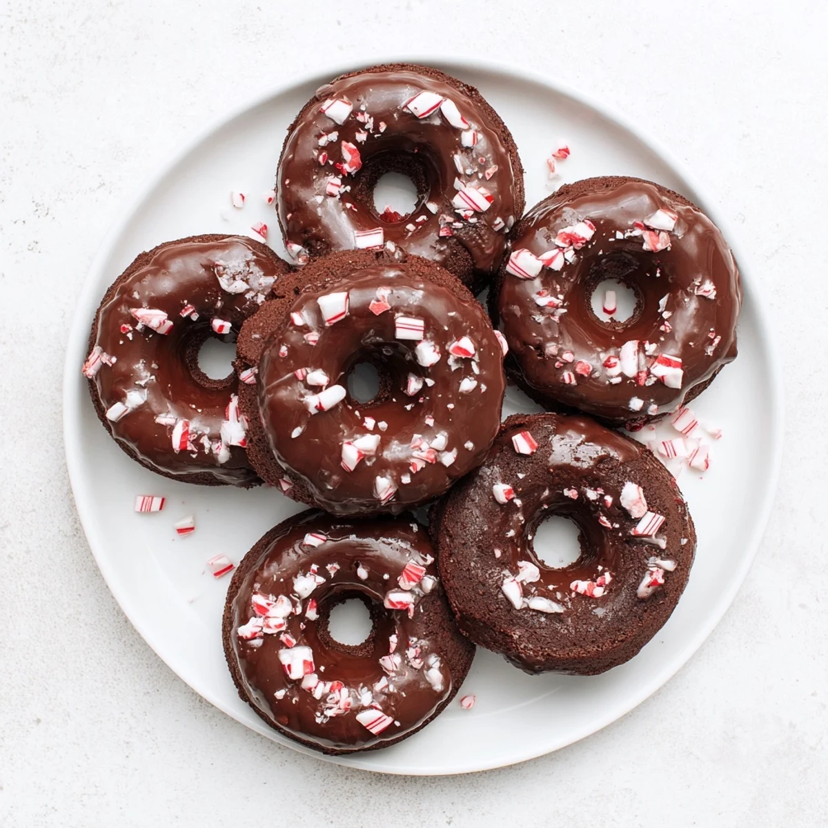 Festive Chocolate Peppermint Mochi Donuts on a plate, perfect for holiday dessert parties.