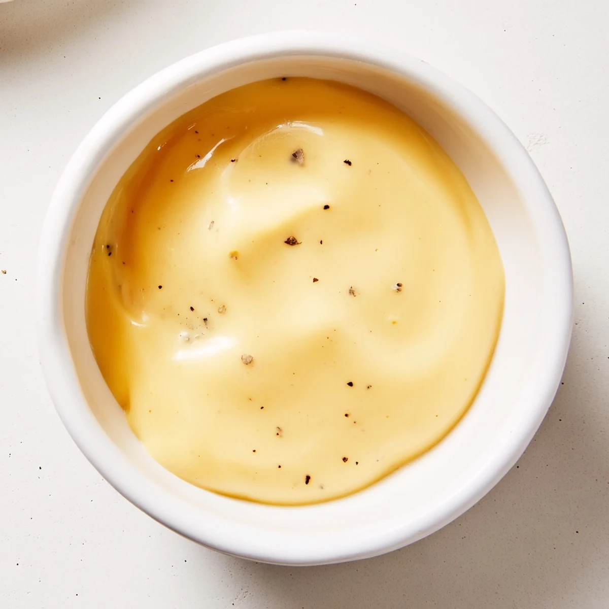 Steaming bowl of Snappy Cheddar Sauce drizzled over golden baked potatoes, ready to serve.