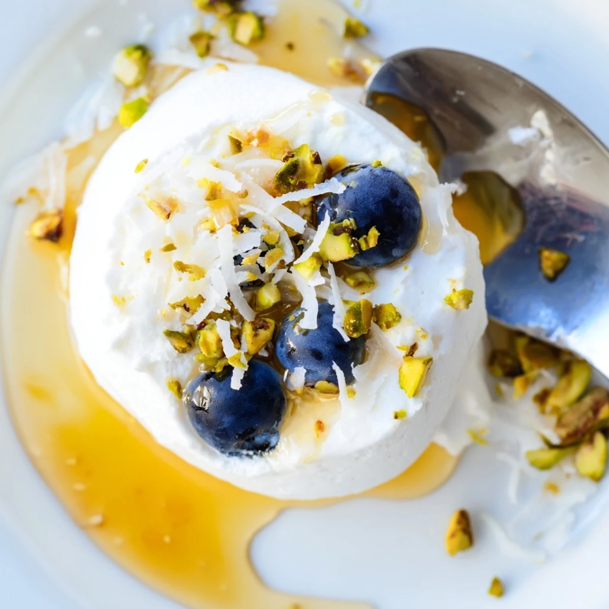 Frozen blueberry Greek yogurt bites arranged on a baking sheet with fresh blueberries nestled in creamy vanilla yogurt mounds