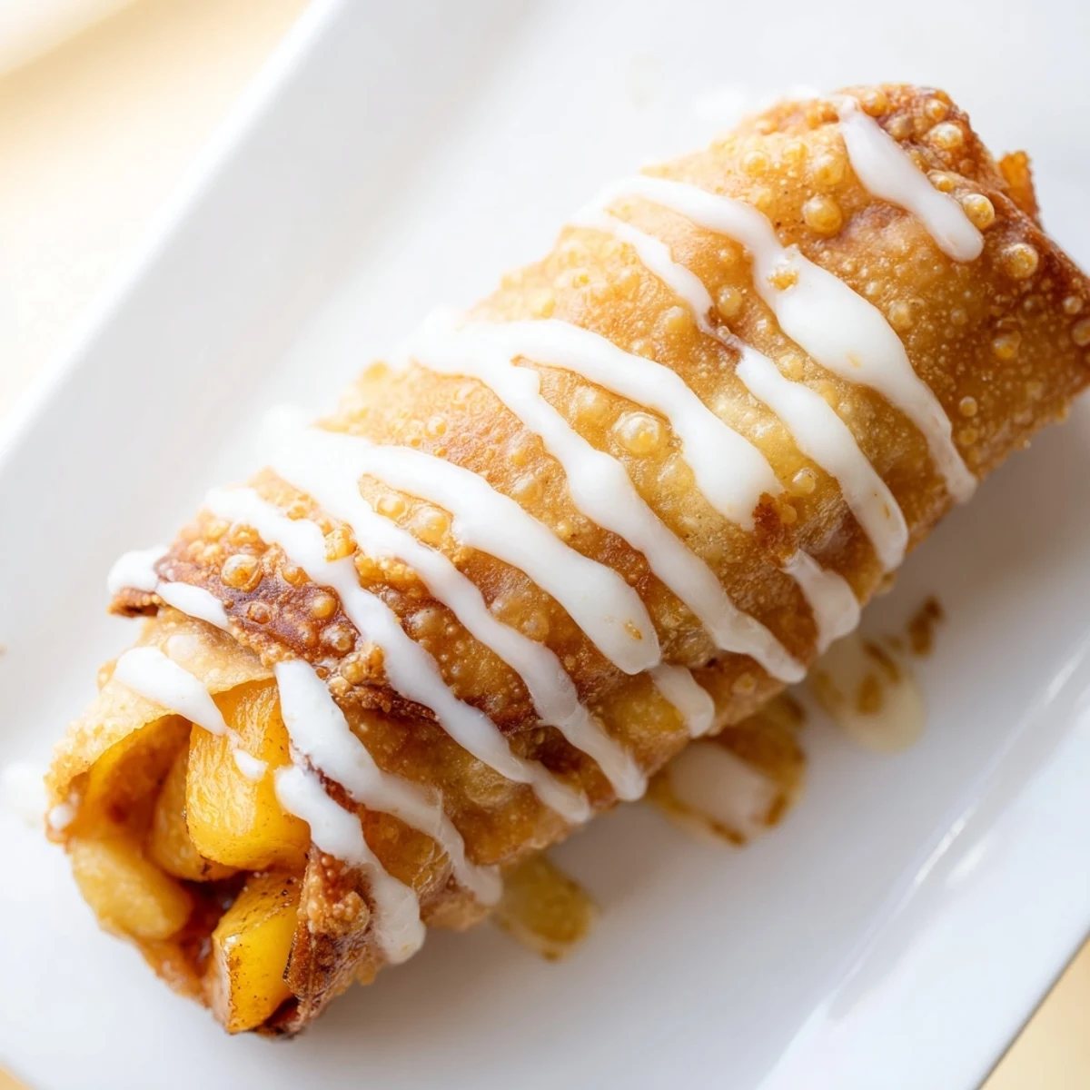 Crispy fried dessert rolls filled with warm cinnamon spiced peaches and sugar