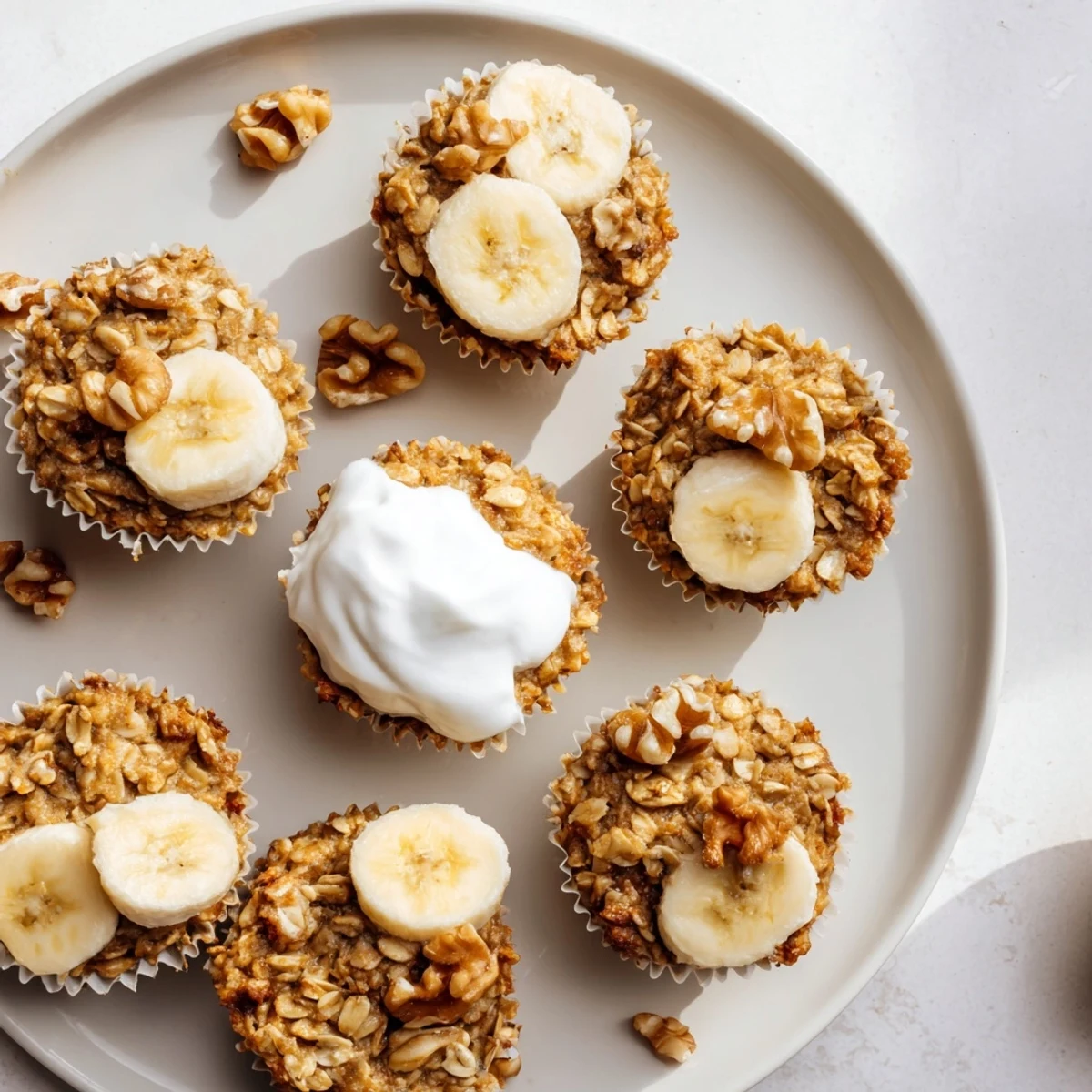 Portable banana baked oatmeal cups sprinkled with cinnamon and topped with vanilla Greek yogurt dollop