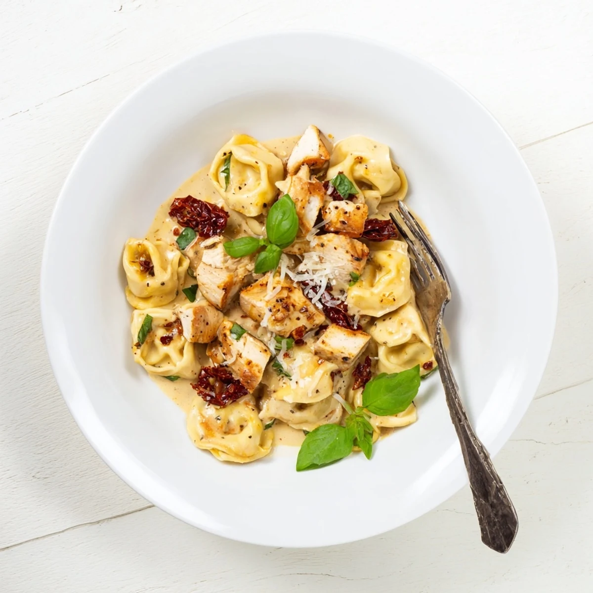 One-pot chicken tortellini skillet with heavy cream sauce and fresh basil garnish