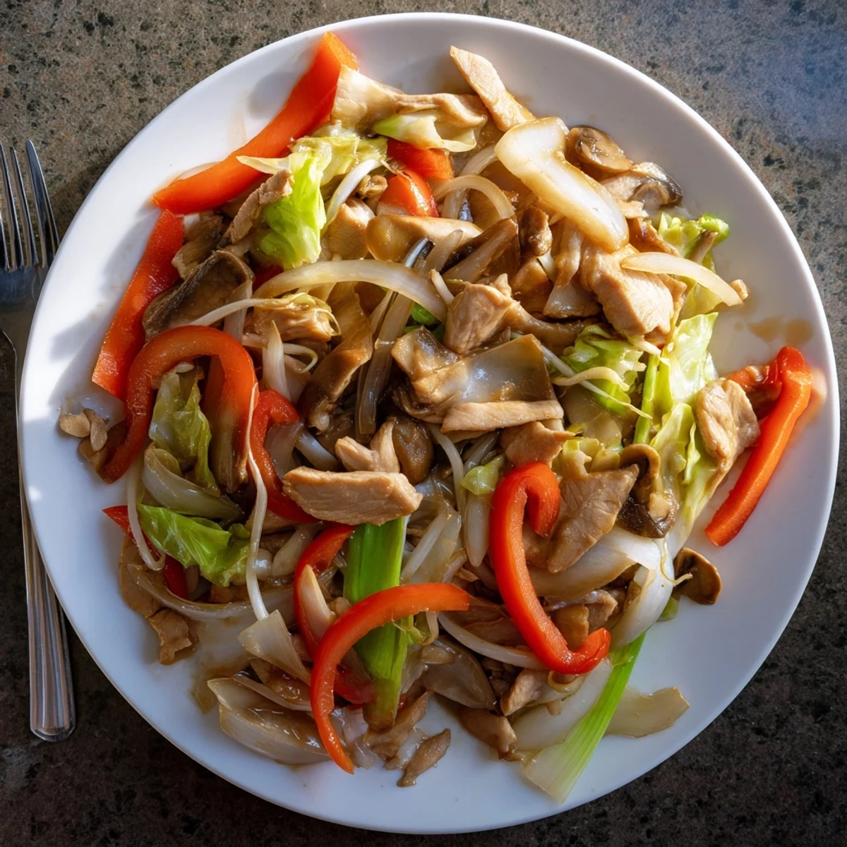Sizzling Chinese-American Chop Suey served over steamed rice with vibrant peppers and bean sprouts