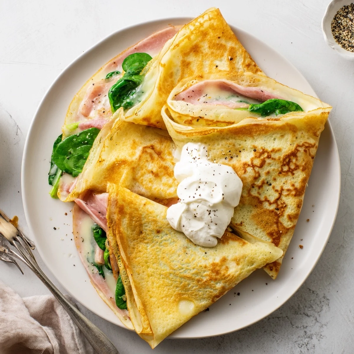 Thin French savory crepes folded around ham and creamy crème fraîche filling
