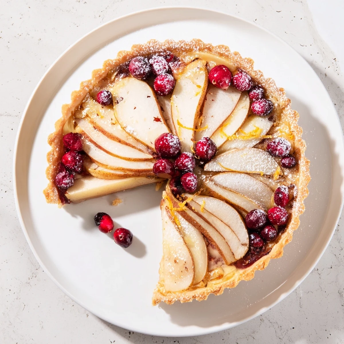 Golden cranberry pear tart arranged in rustic spirals atop a flaky buttery pastry crust