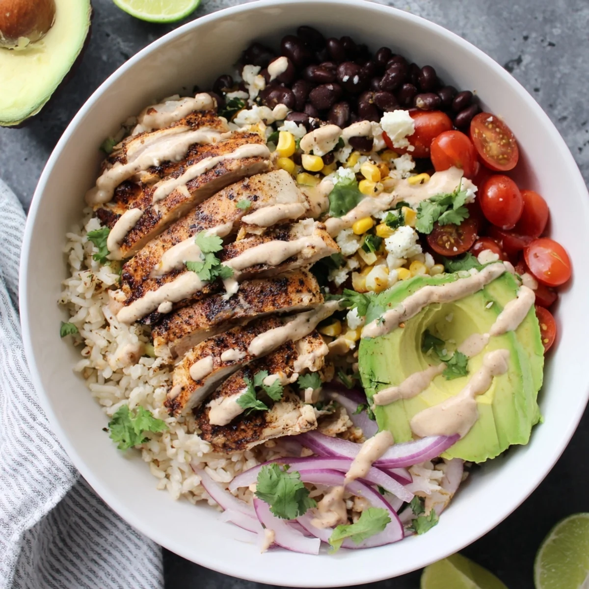 Vibrant Baja style chicken bowl featuring juicy grilled meat over zesty lime rice with colorful fresh vegetables and creamy chipotle drizzle