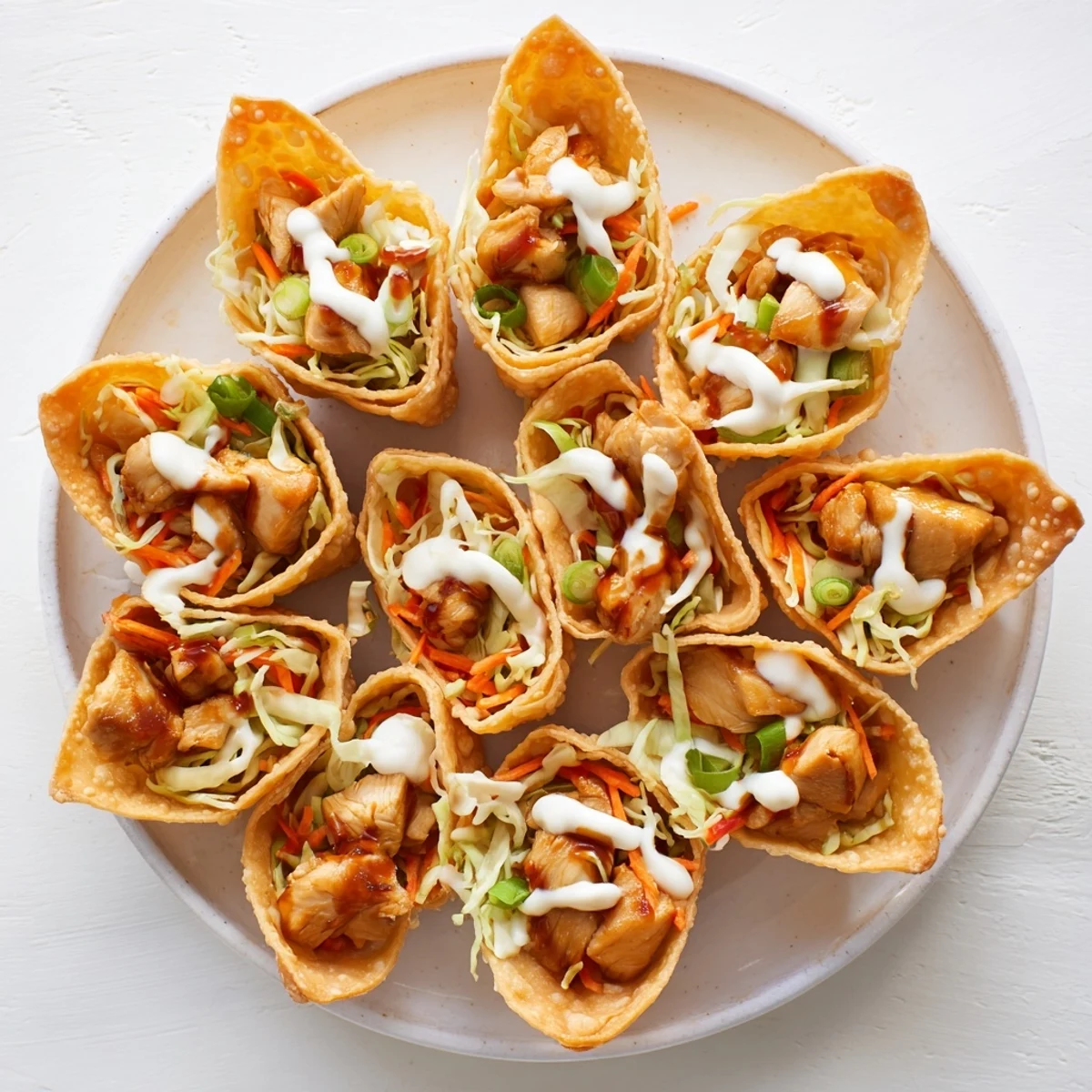 Savory chicken-filled wonton taco shells drizzled with spicy mayo and fresh vegetable crunch