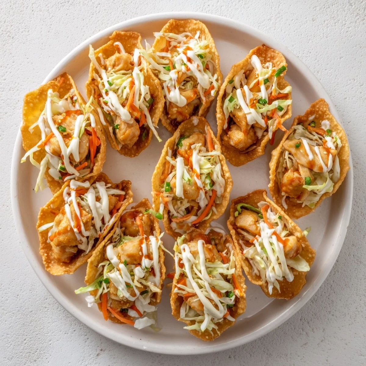 Golden crispy chicken wonton tacos topped with colorful cabbage slaw and zesty Asian sauce