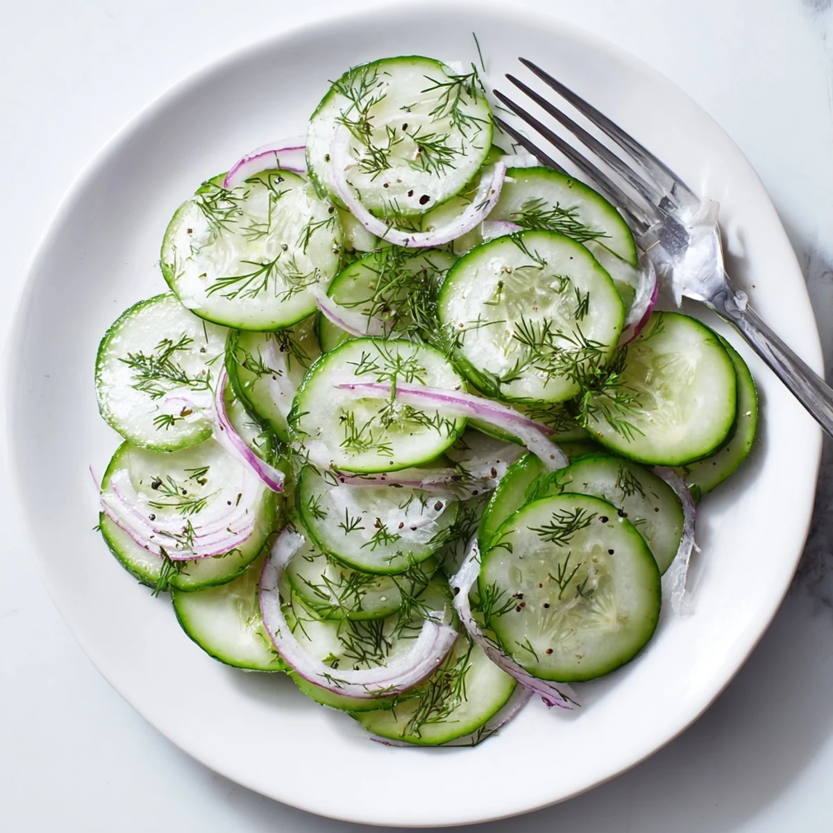 Fresh cucumber salad with thinly sliced cucumbers and red onion in tangy vinegar dressing