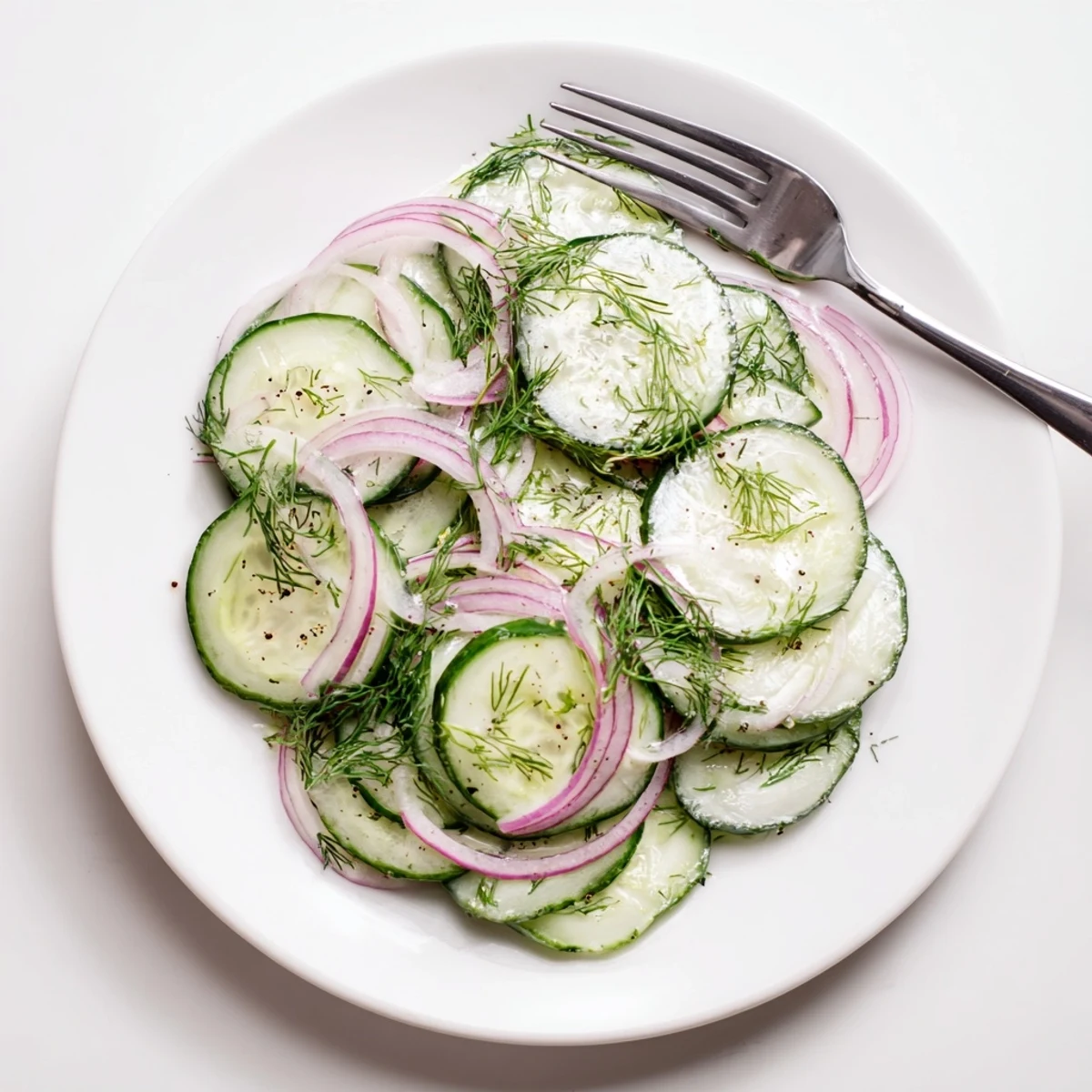Crisp cucumber salad bowl topped with fresh dill and light olive oil vinaigrette