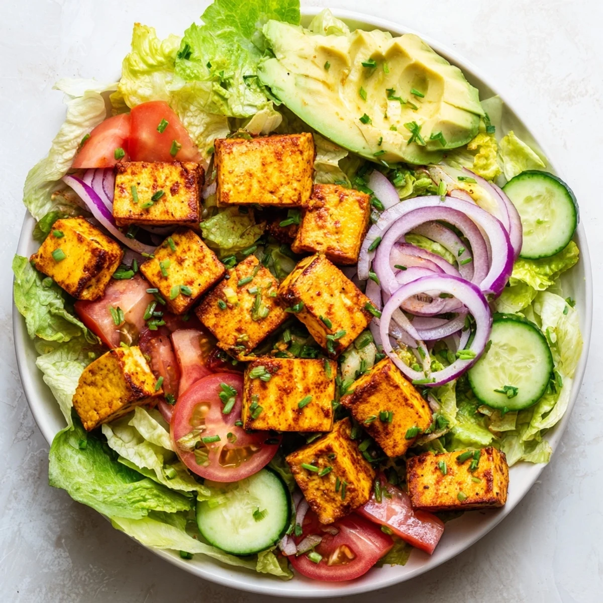 Light summer salad with smoky pan-fried tofu layered over crisp romaine lettuce and vibrant chopped tomatoes