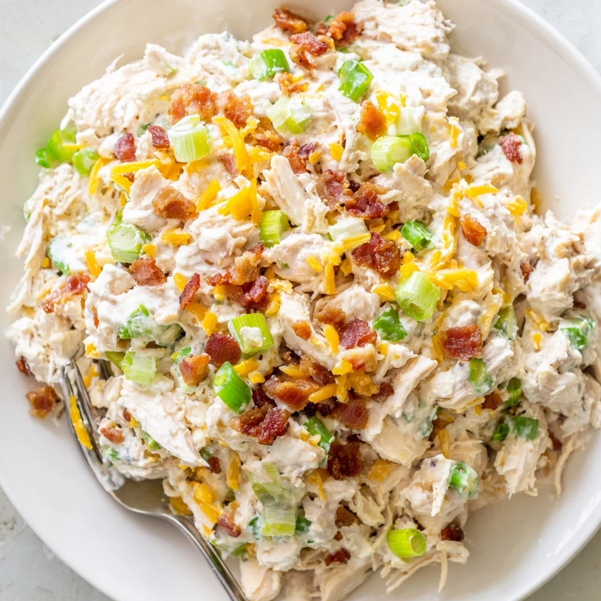 Rustic wooden serving board displaying low carb jalapeno popper keto chicken salad with crisp celery sticks alongside for dipping and snacking
