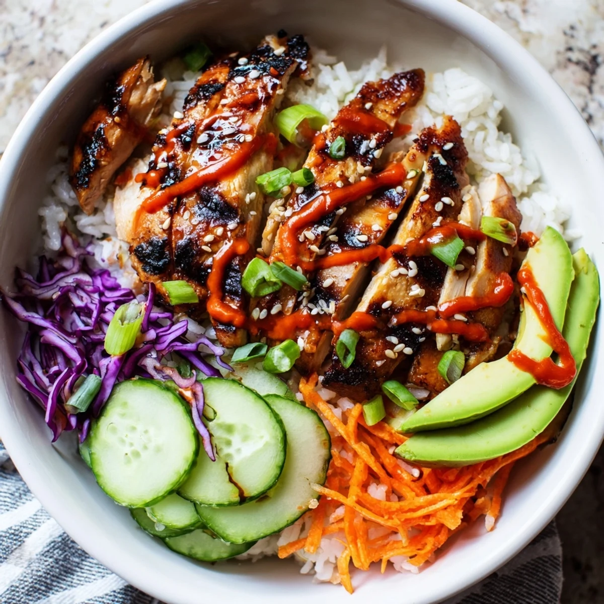 Succulent Korean BBQ chicken bowl served over steamed jasmine rice with avocado slices and zesty chili paste sauce