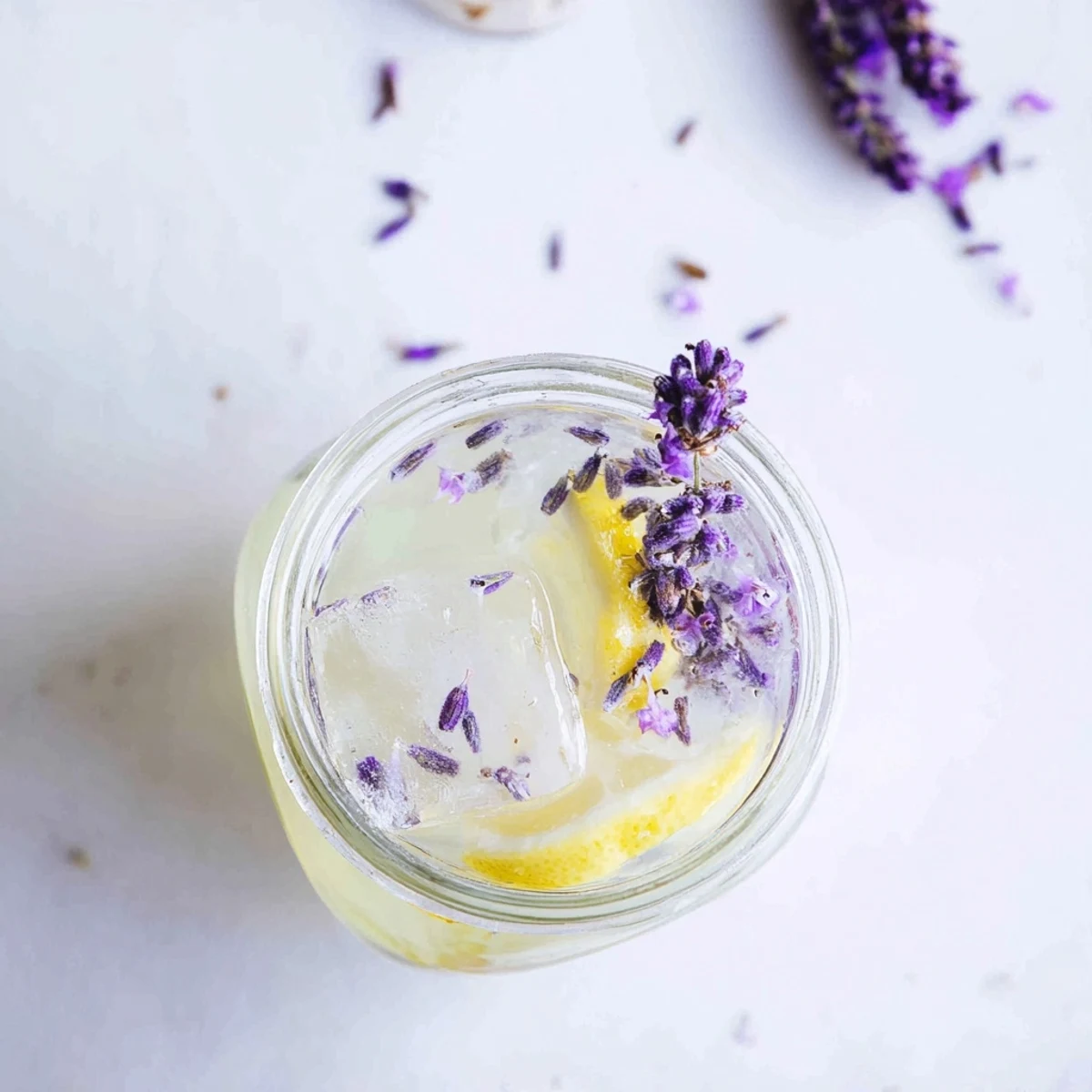 Homemade lavender lemonade displaying golden color with floating ice cubes and citrus wedges