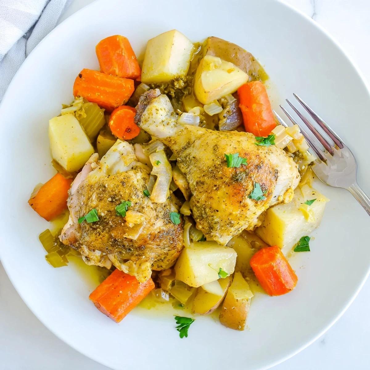Tender slow cooker chicken dinner with carrots, potatoes, and herb sauce in a rustic bowl