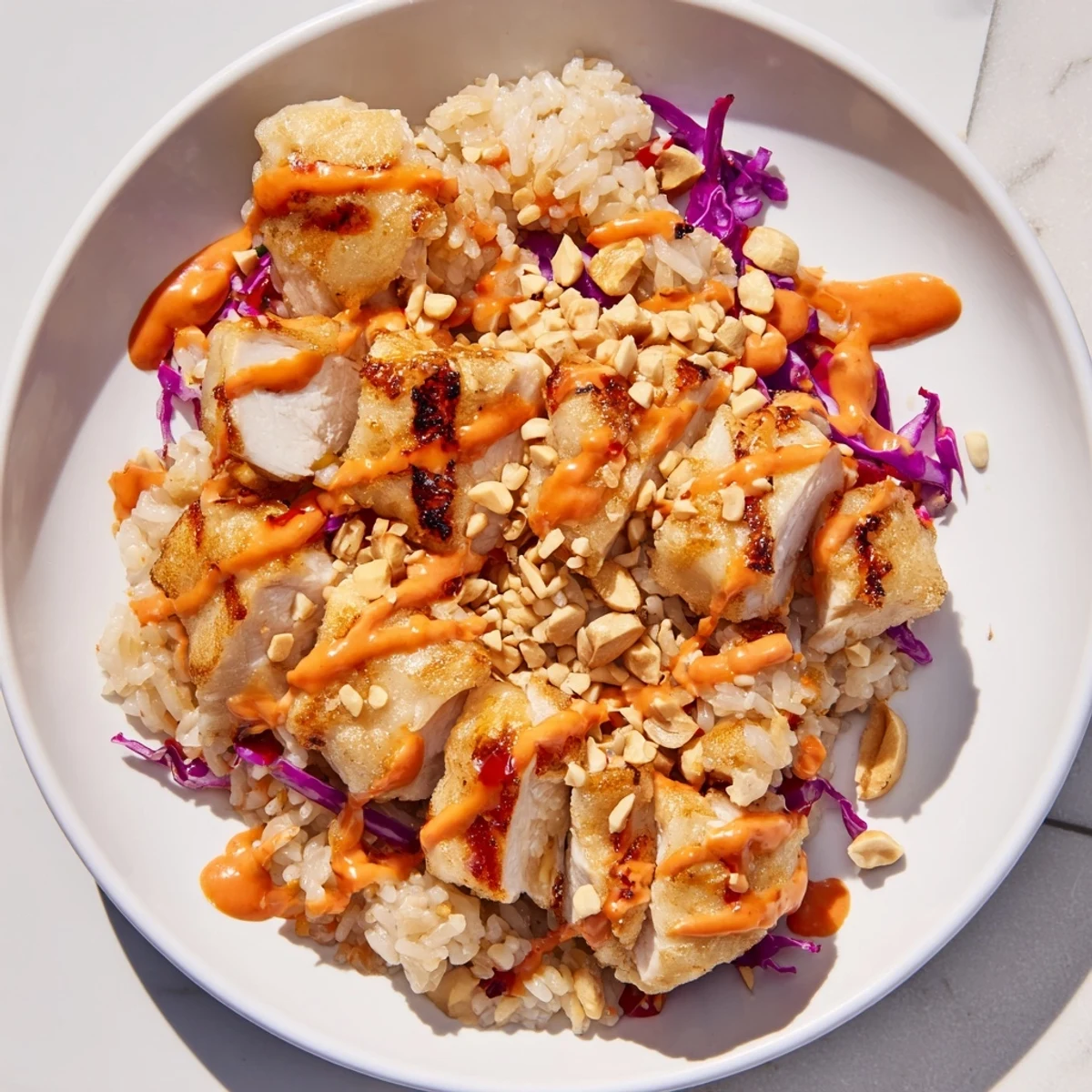 Colorful vegetables and tender chicken over crispy rice drizzled with Bang Bang sauce