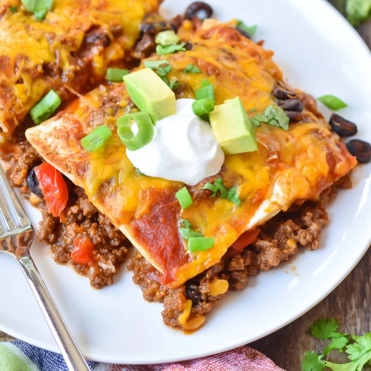Cheesy Beef Skillet Enchiladas shown sliced, steam rising, ready to serve family-style