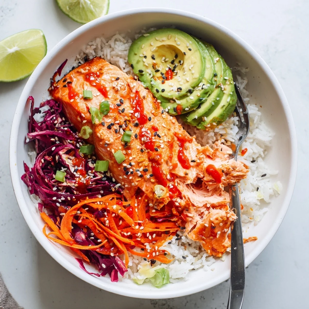 Colorful Bang Bang Salmon Bowls Recipe served over jasmine rice, sliced avocado