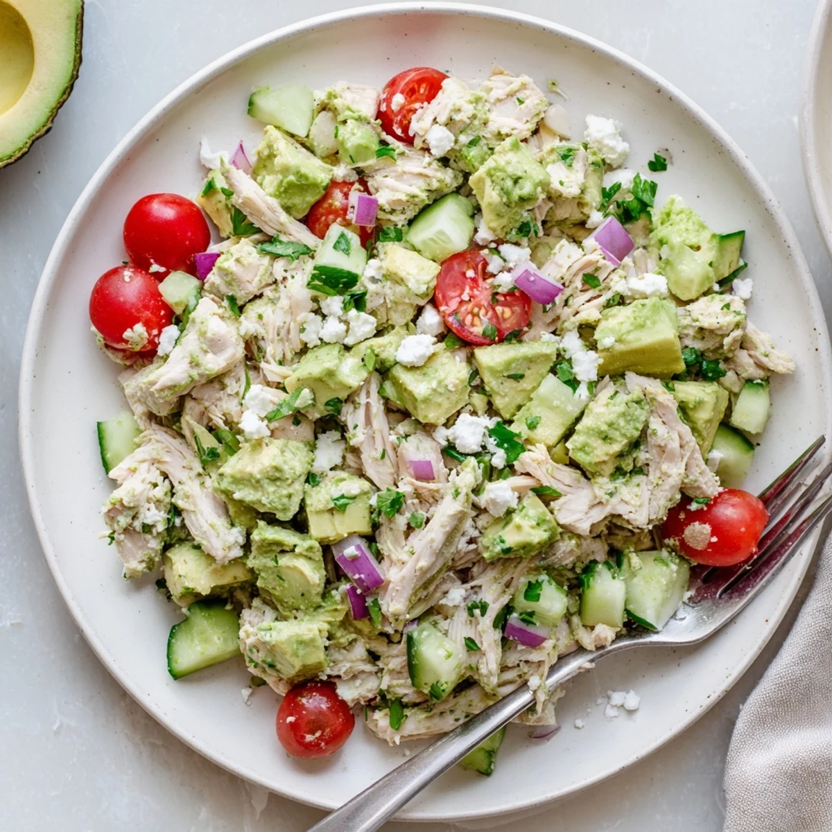 Cold Avocado Chicken Salad in a bowl, avocado chunks and crisp cucumber