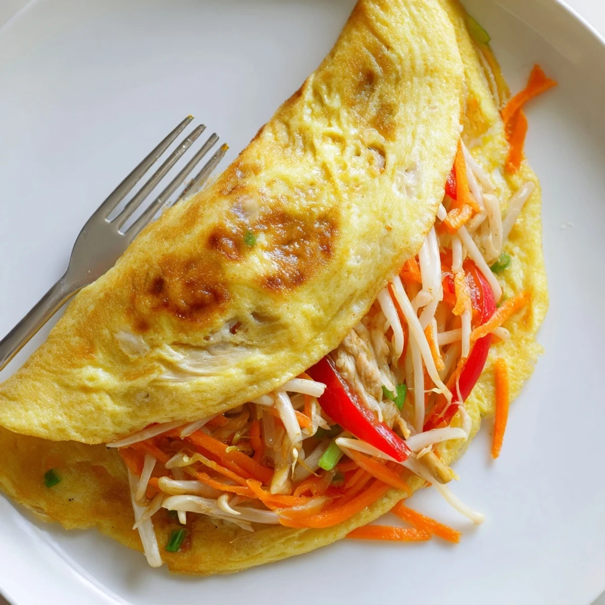 Savory Chinese omelette filled with julienned carrots and chicken served steaming hot