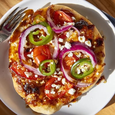 Sweet Heat Honey Garlic Flatbread Pizza sliced on a wooden board, drizzled with spicy-sweet sauce and garnished with fresh cilantro.
