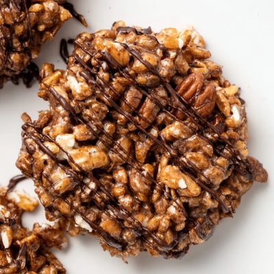 A close-up view of No Bake Coffee Crunch Rice Krispie Cookies showing the crispy texture and chopped pecans on a marble countertop.